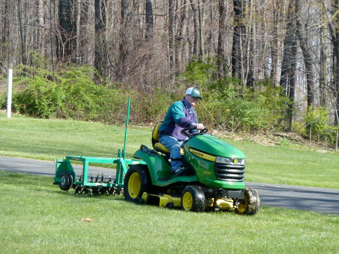 technician using equipment to perform aeration and overseeding